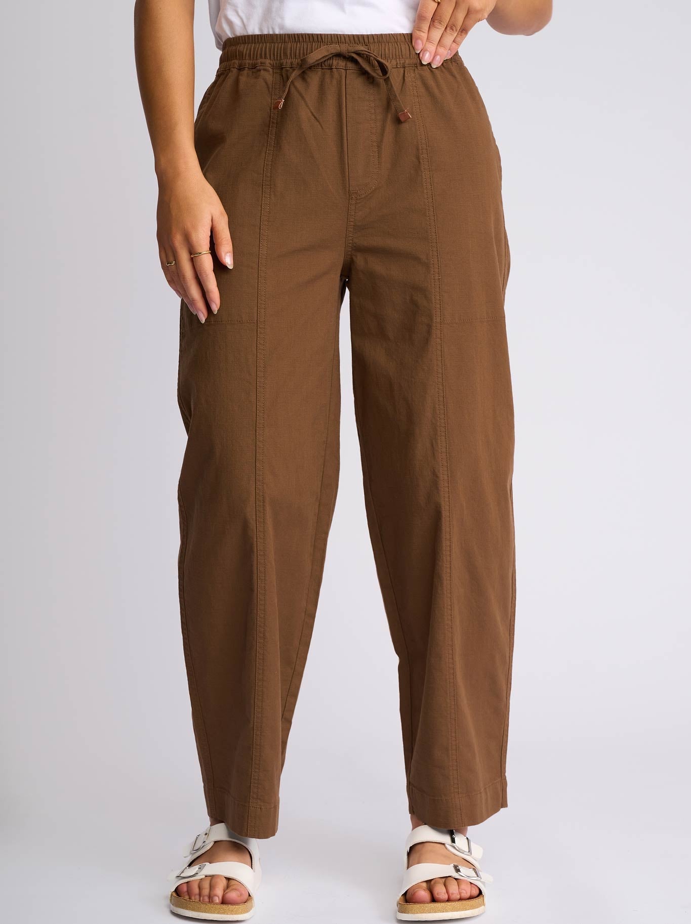 Image of a model wearing Pants. Product name - Vassalli Dione Barrel Pant in Pecan colour by brand - Vassalli
