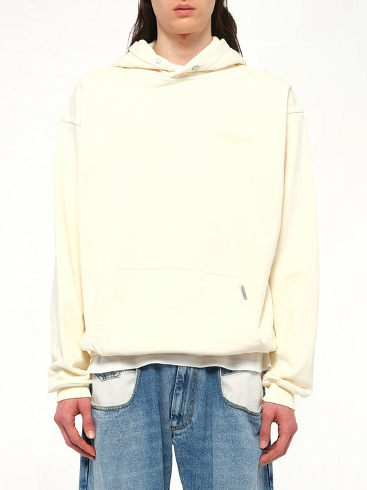 Image of a model wearing Outerwear. Product name - Represent Owners Club Hoodie in Buttercream colour by brand - REPRESENT