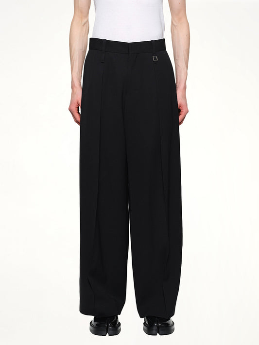 Image of a model wearing Pants. Productname: WOOYOUNGMI Pleated Pants in BLACK colour by brand - WOOYOUNGMI