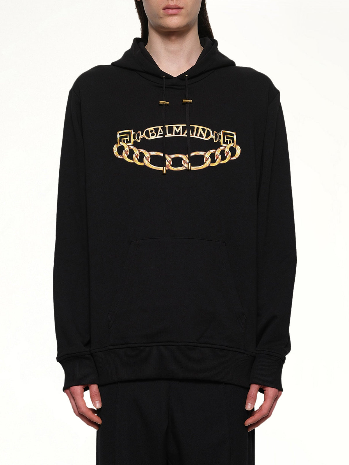 Image of a model wearing Outerwear. Product name - Balmain Chian Logo Hoodie in Black colour by brand - BALMAIN