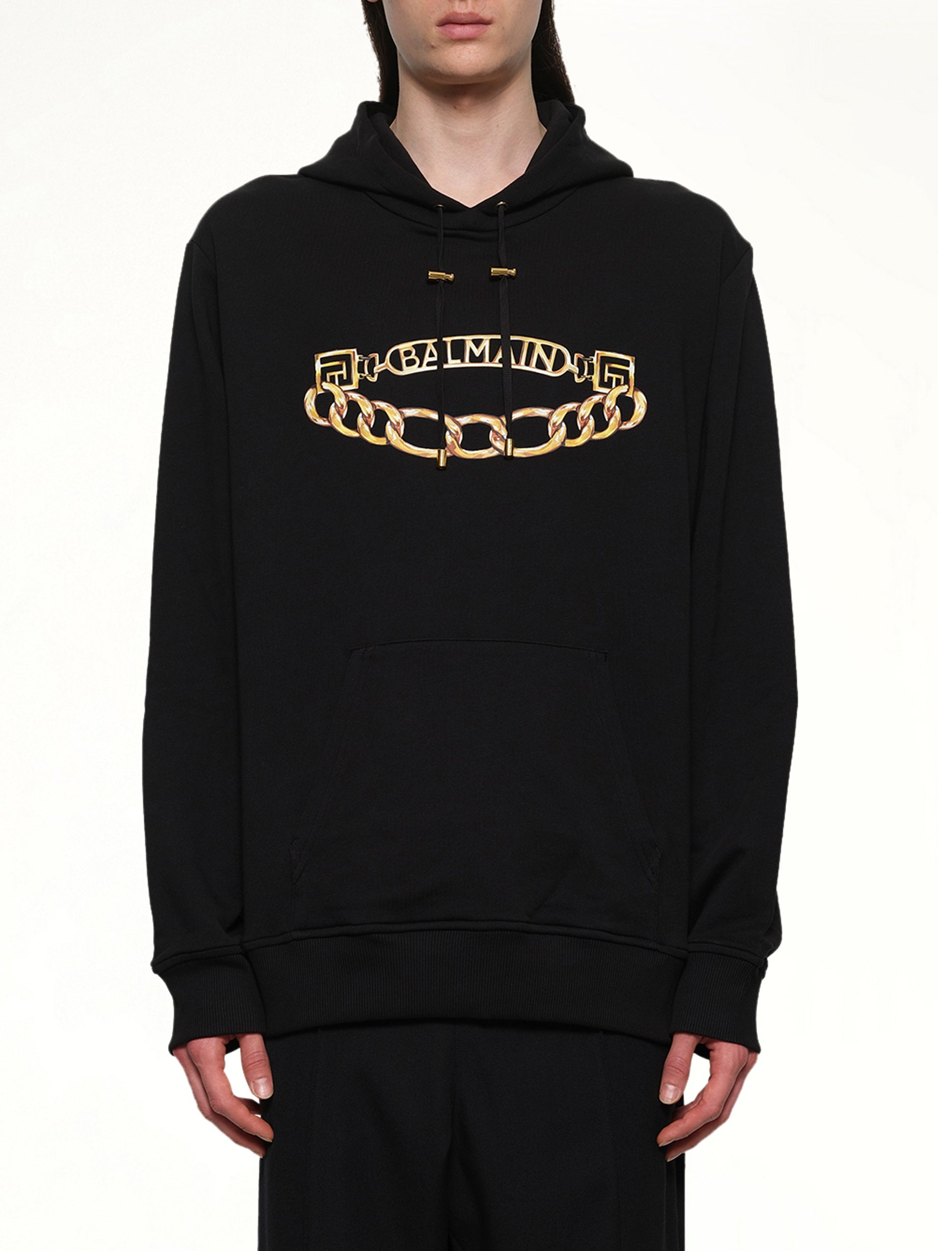 Image of a model wearing Outerwear. Product name - Balmain Chian Logo Hoodie in Black colour by brand - BALMAIN