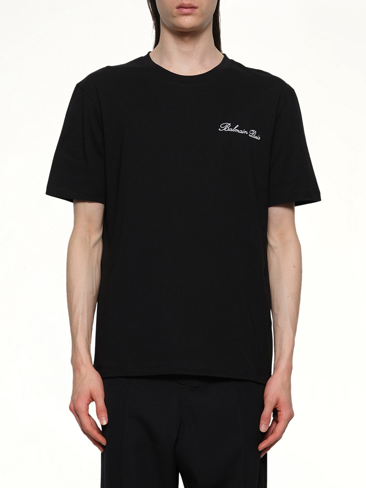 Image of a model wearing Tops. Productname: BALMAIN Balmain Signature Embroidered T-Shirt in BLACK/WHITE colour by brand - BALMAIN