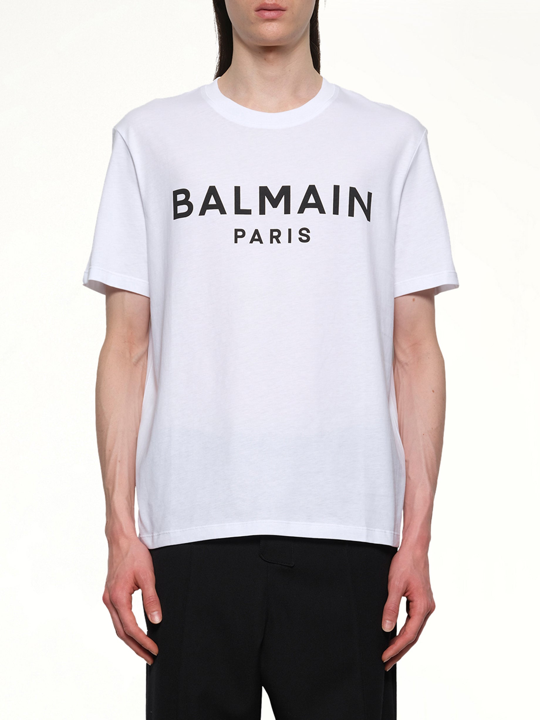 Image of a model wearing Tops. Productname: BALMAIN Logo Printed Straight Fit T-shirt in White/Black colour by brand - BALMAIN
