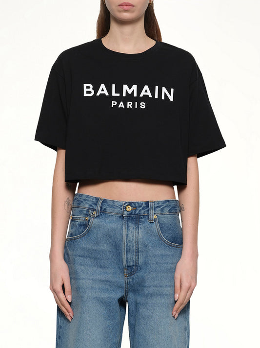 Image of a model wearing Tops. Productname: BALMAIN Cropped Print Logo Eco T-Shirt in BLACK/WHITE colour by brand - BALMAIN