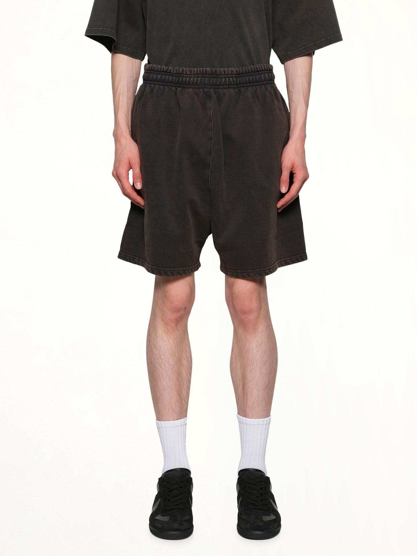 Image of a model wearing Shorts. Product name - Standard Sweatshorts in Black colour by brand - ENTIRE STUDIOS