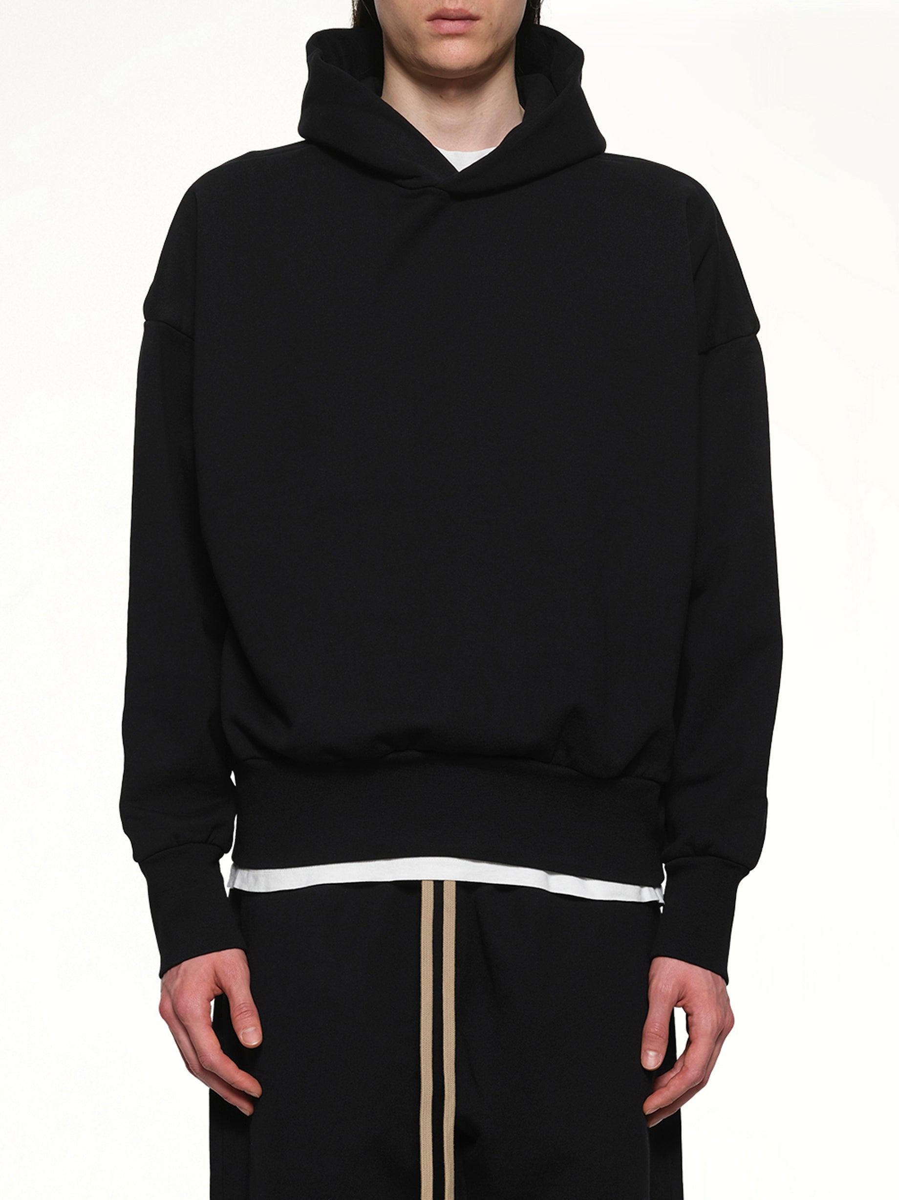 Image of a model wearing Outerwear. Product name - Logo Hoodie in Black colour by brand - FEAR OF GOD