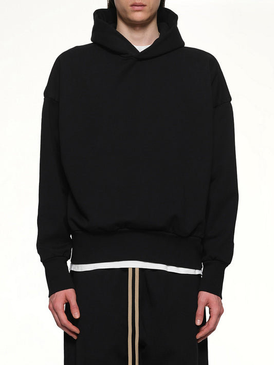 Image of a model wearing Outerwear. Product name - Logo Hoodie in Black colour by brand - FEAR OF GOD