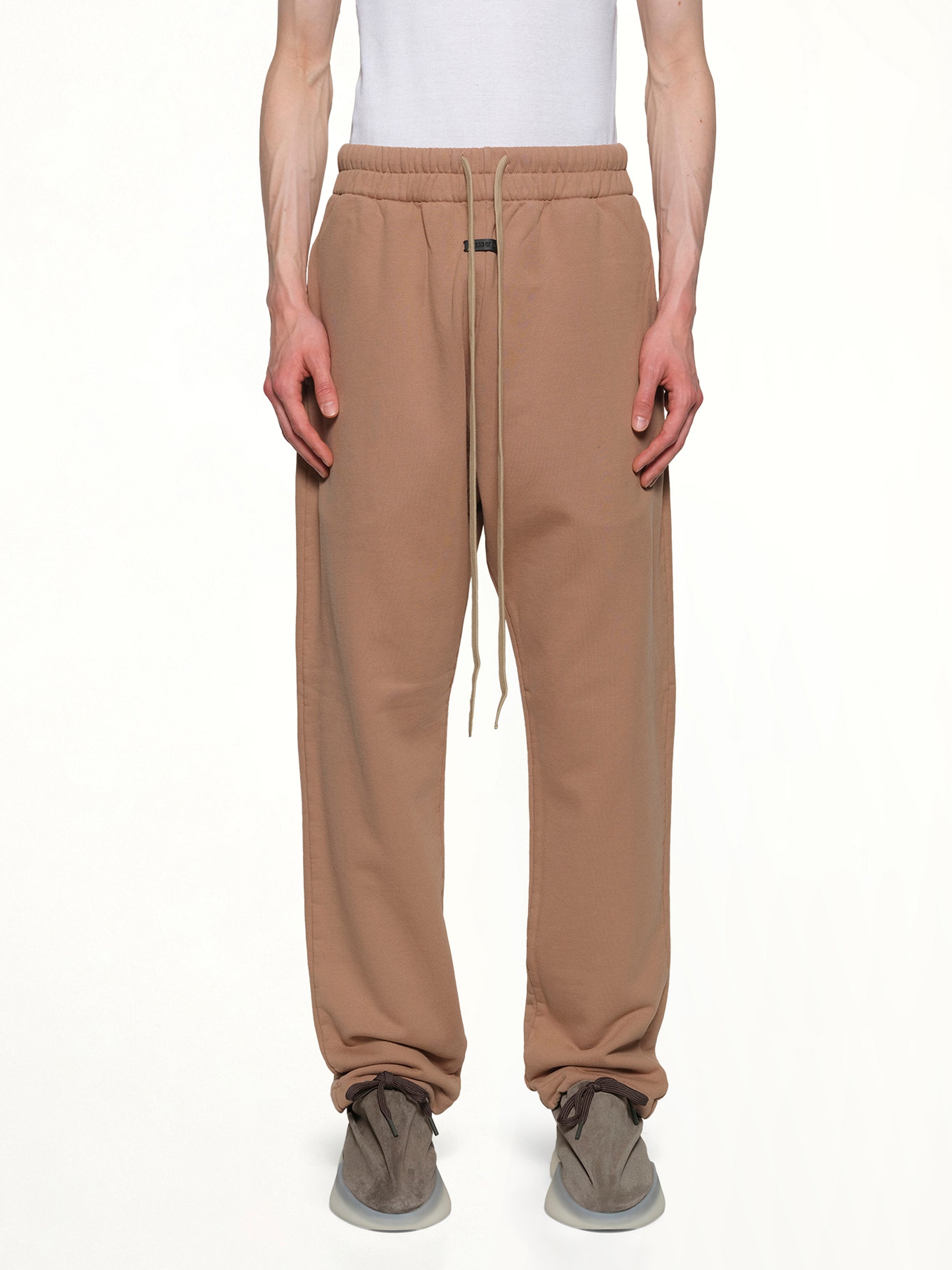 Image of a model wearing Pants. Product name - Relaxed Sweatpant in Dune colour by brand - FEAR OF GOD