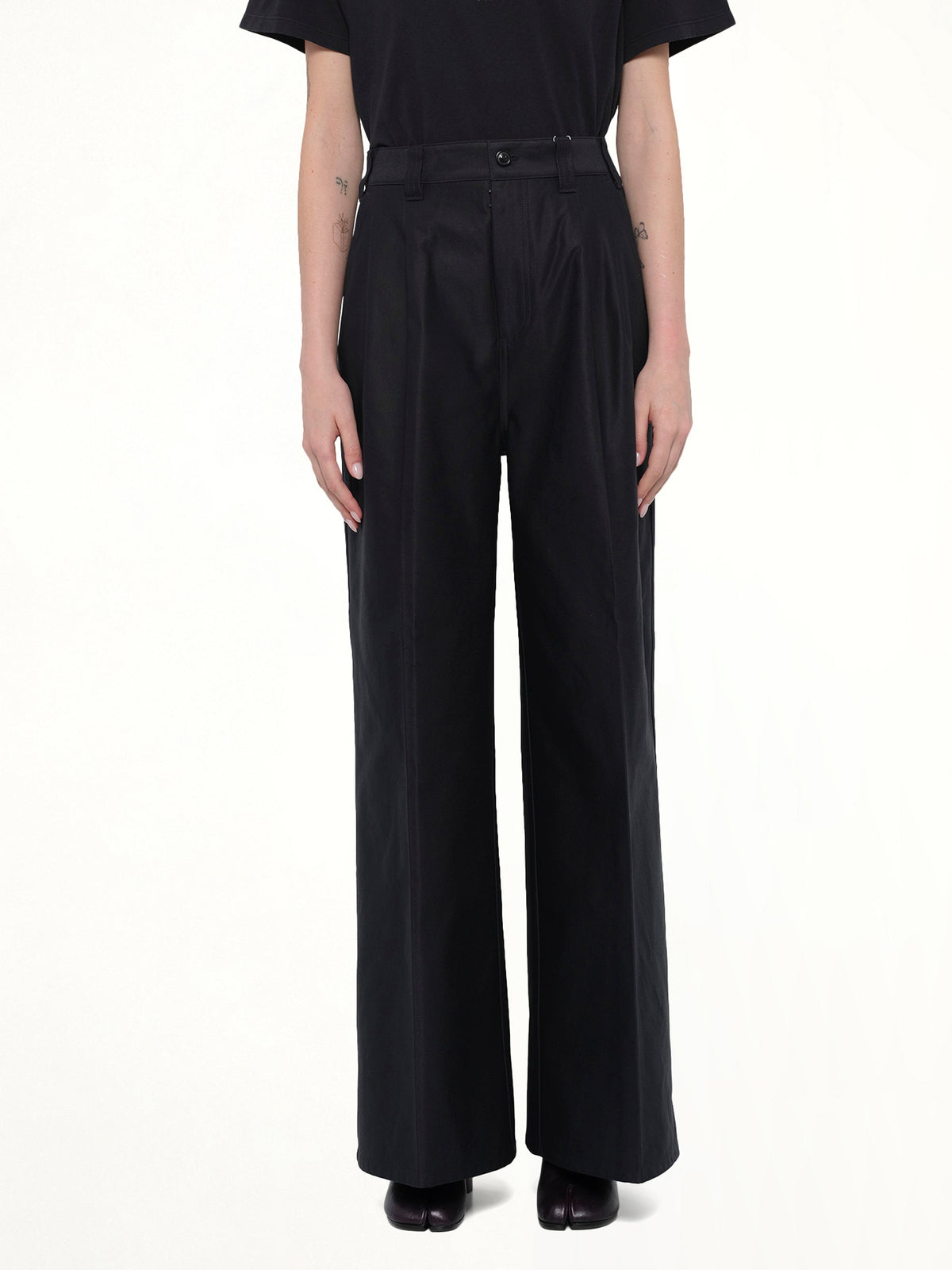 Image of a model wearing Pants. Product name - Cotton Palazzo Trouser in Black colour by brand - MAISON MARGIELA