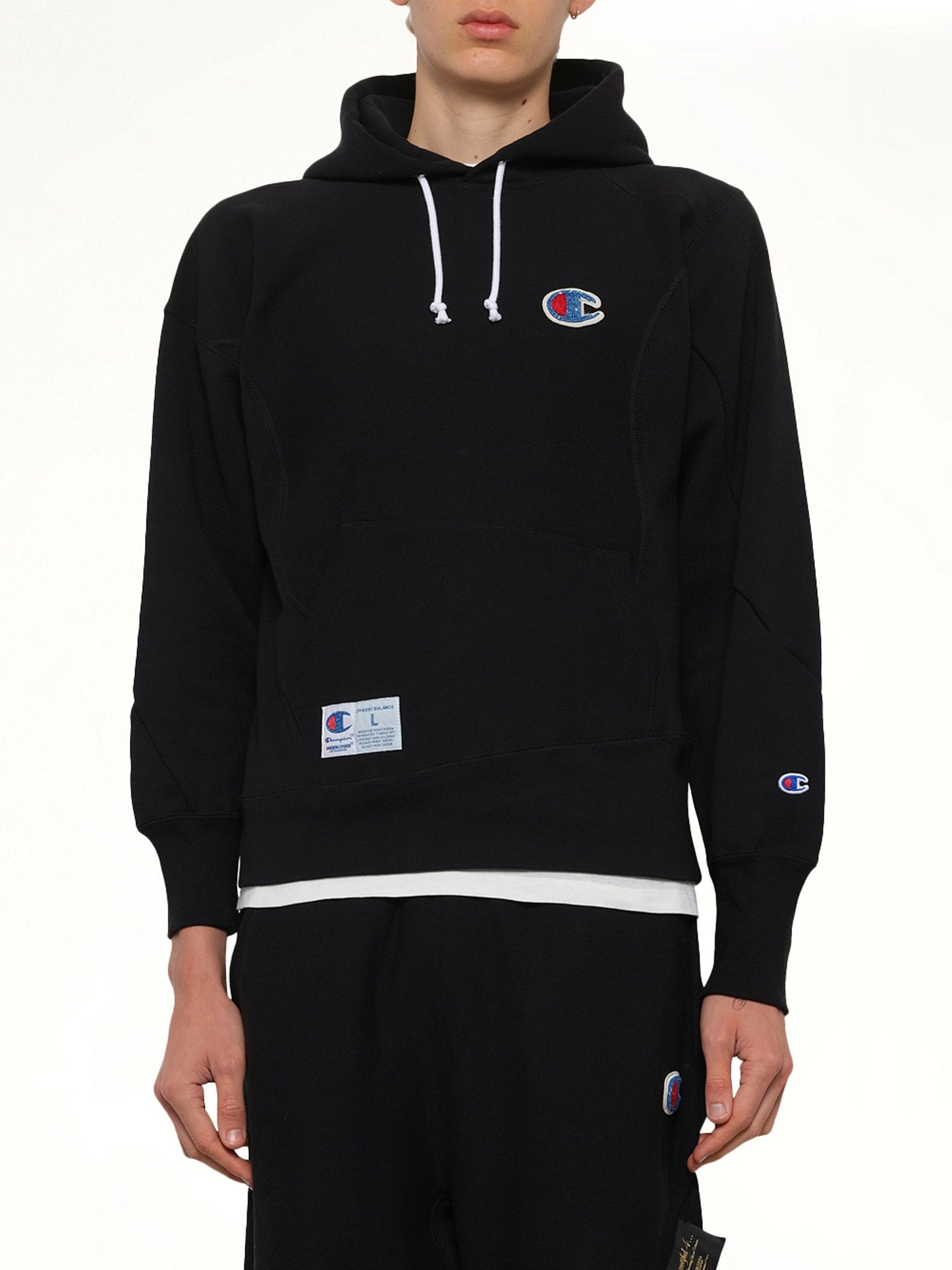 Image of a model wearing Outerwear. Product name - Undercover X Champion Hoodie in Black colour by brand - UNDERCOVER