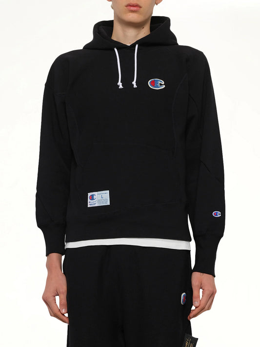 Image of a model wearing Outerwear. Product name - Undercover X Champion Hoodie in Black colour by brand - UNDERCOVER