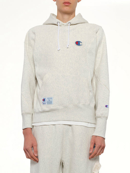 Image of a model wearing Outerwear. Productname: UNDERCOVER Undercover X Champion Hoodie in Oatmeal colour by brand - UNDERCOVER