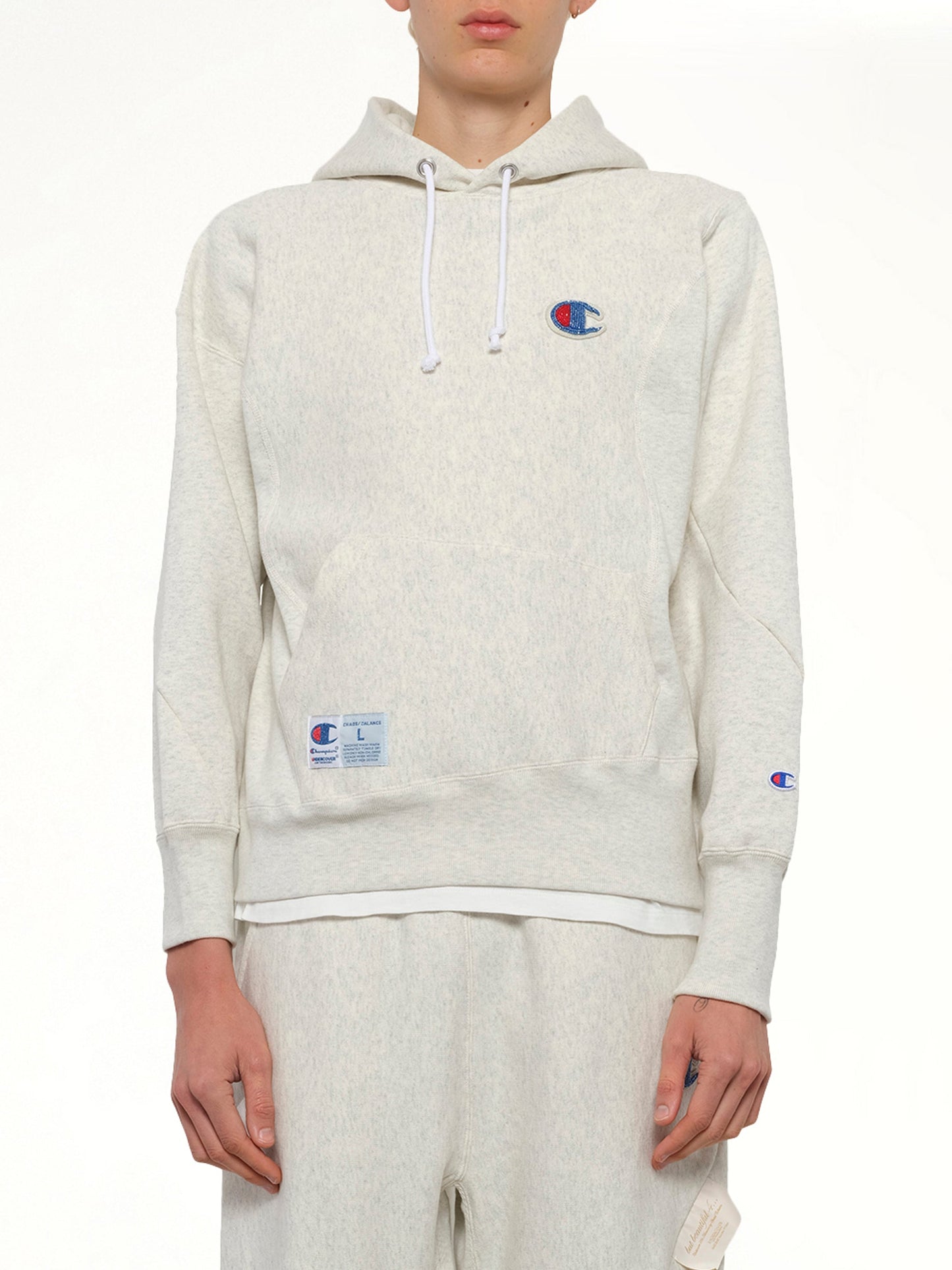 Image of a model wearing Outerwear. Product name - Undercover X Champion Hoodie in Beige colour by brand - UNDERCOVER