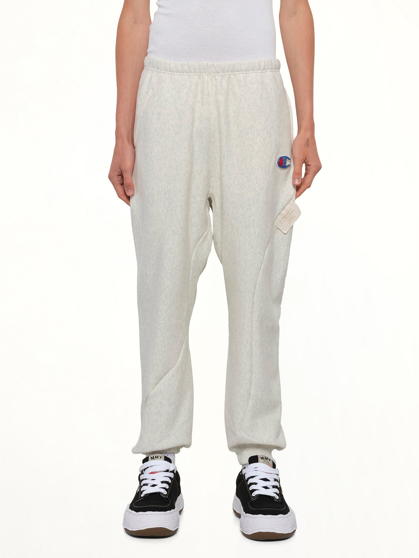 Image of a model wearing Pants. Product name - Undercover X Champion Sweatpants in Beige colour by brand - UNDERCOVER