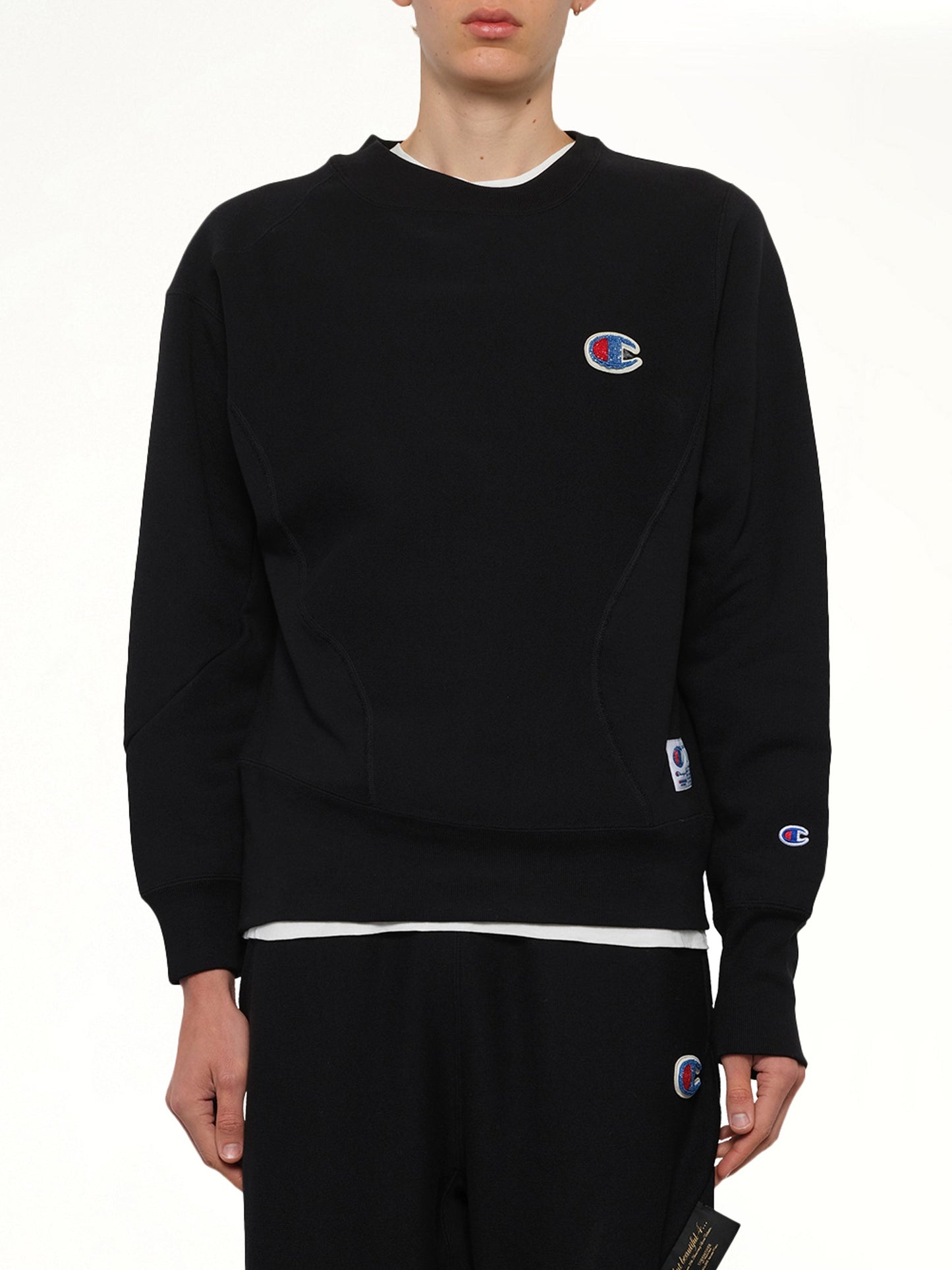 Image of a model wearing Outerwear. Product name - Undercover X Champion Sweatshirt in Black colour by brand - UNDERCOVER