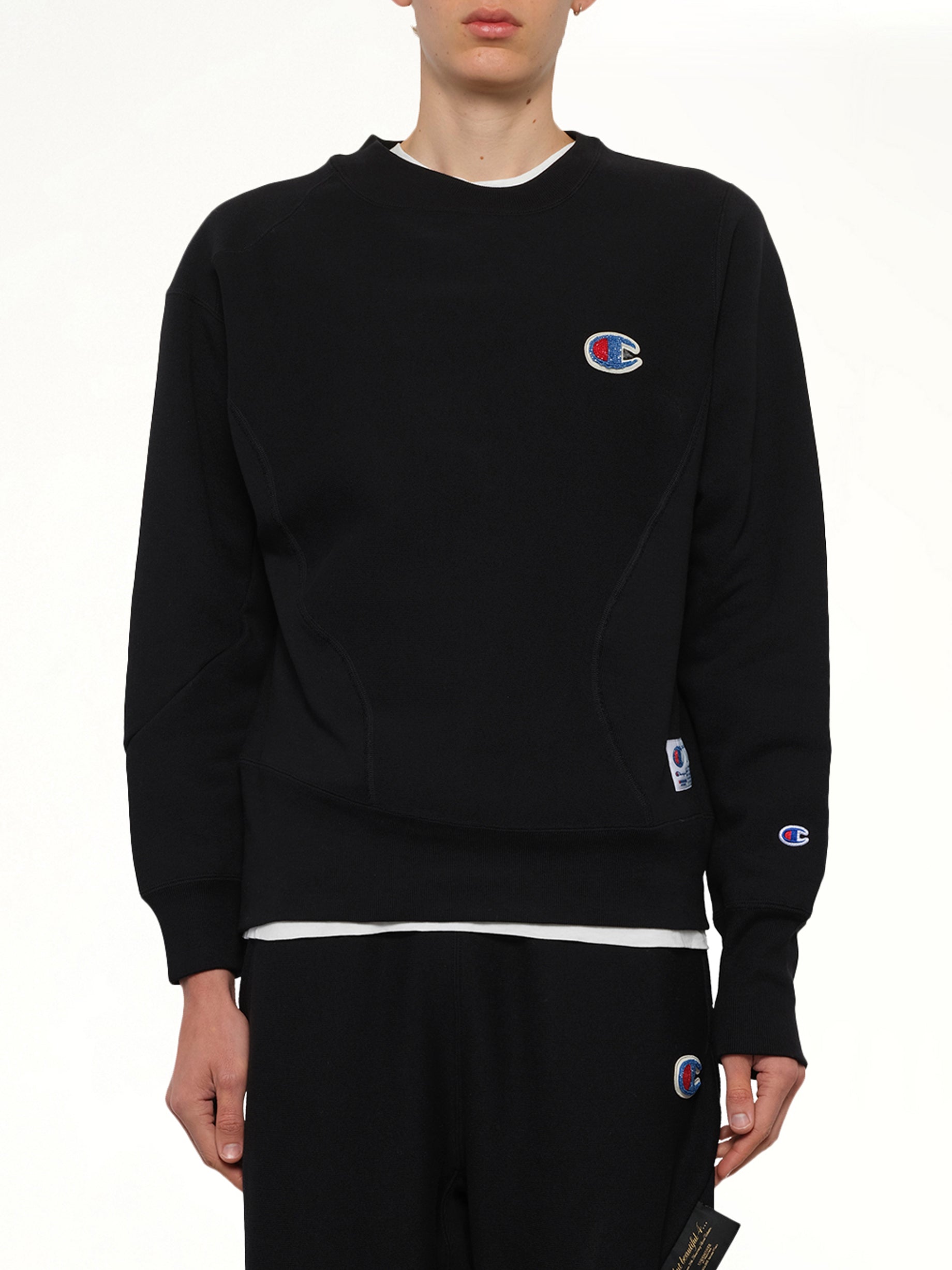 Image of a model wearing Outerwear. Product name - Undercover X Champion Sweatshirt in Black colour by brand - UNDERCOVER