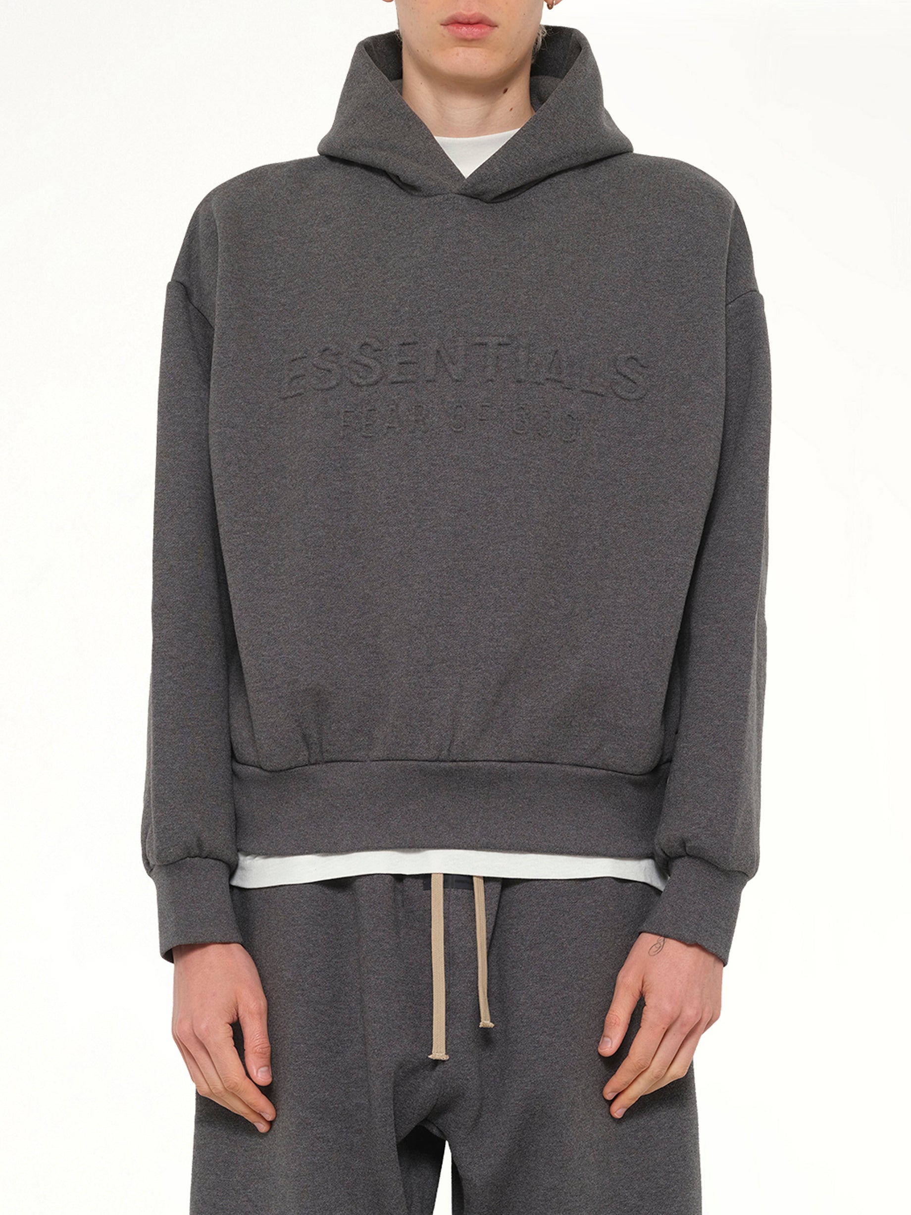 Image of a model wearing Outerwear. Product name - Classic Hoodie in Charcoal Heather colour by brand - FEAR OF GOD ESSENTIALS