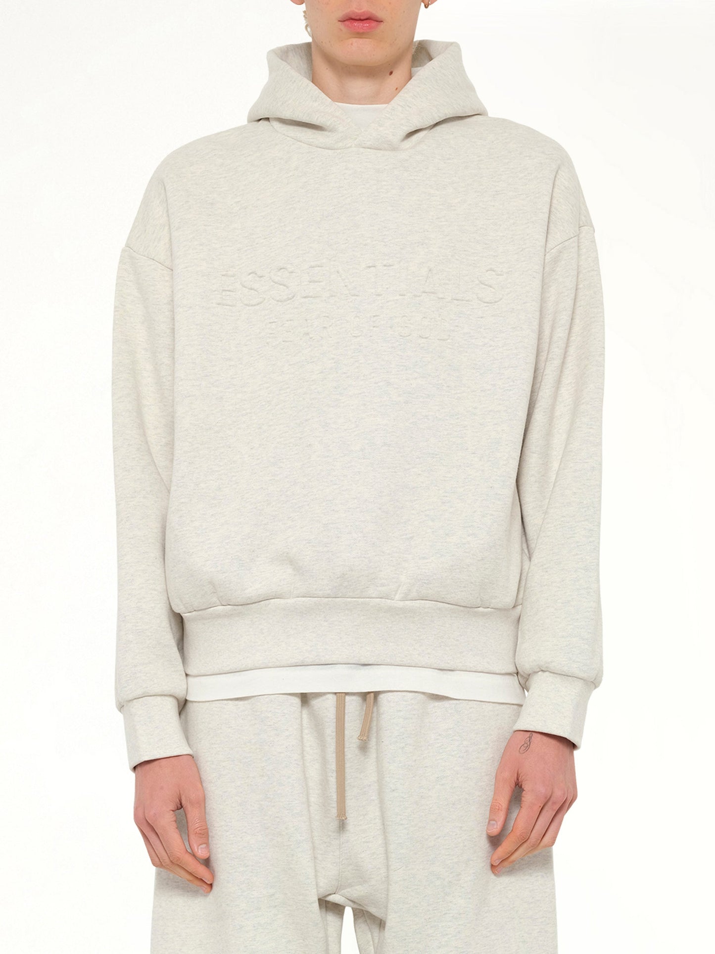 Image of a model wearing Outerwear. Product name - Classic Hoodie in Beige colour by brand - FEAR OF GOD ESSENTIALS