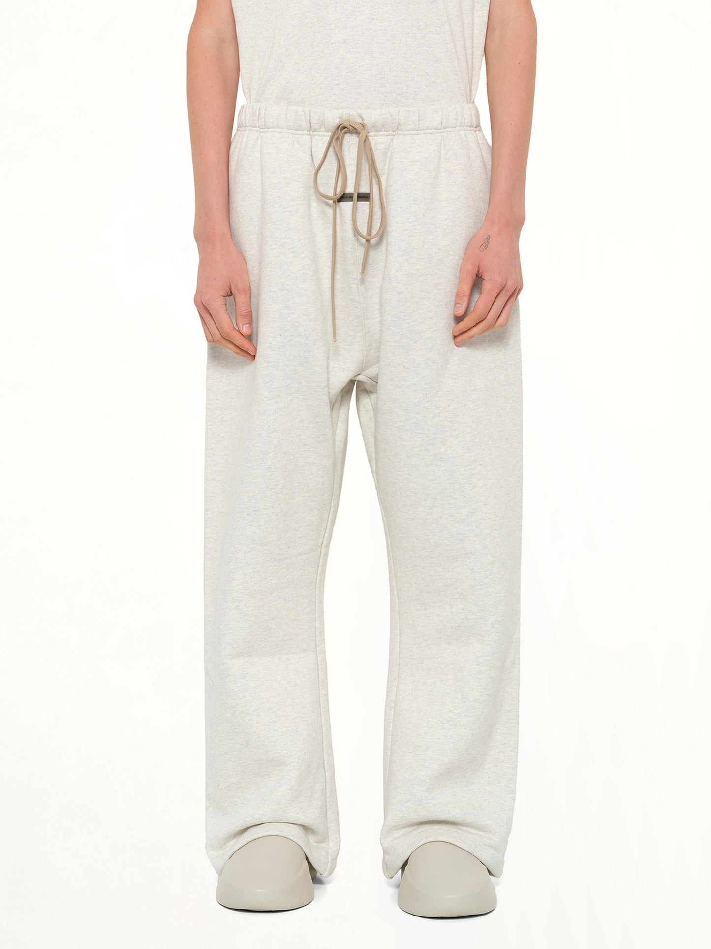 Image of a model wearing Pants. Product name - Flare Sweatpant in Beige colour by brand - FEAR OF GOD ESSENTIALS