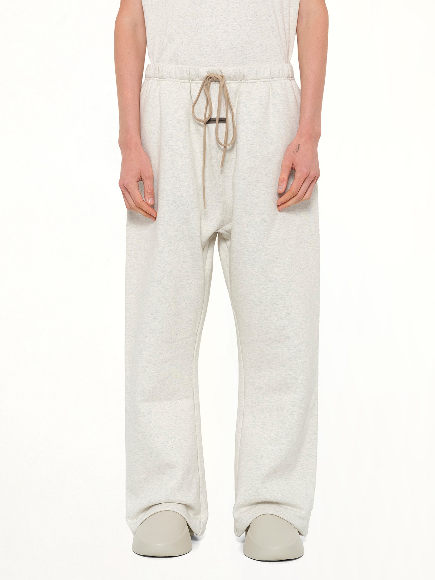 Image of a model wearing Pants. Product name - Flare Sweatpant in Beige colour by brand - FEAR OF GOD ESSENTIALS