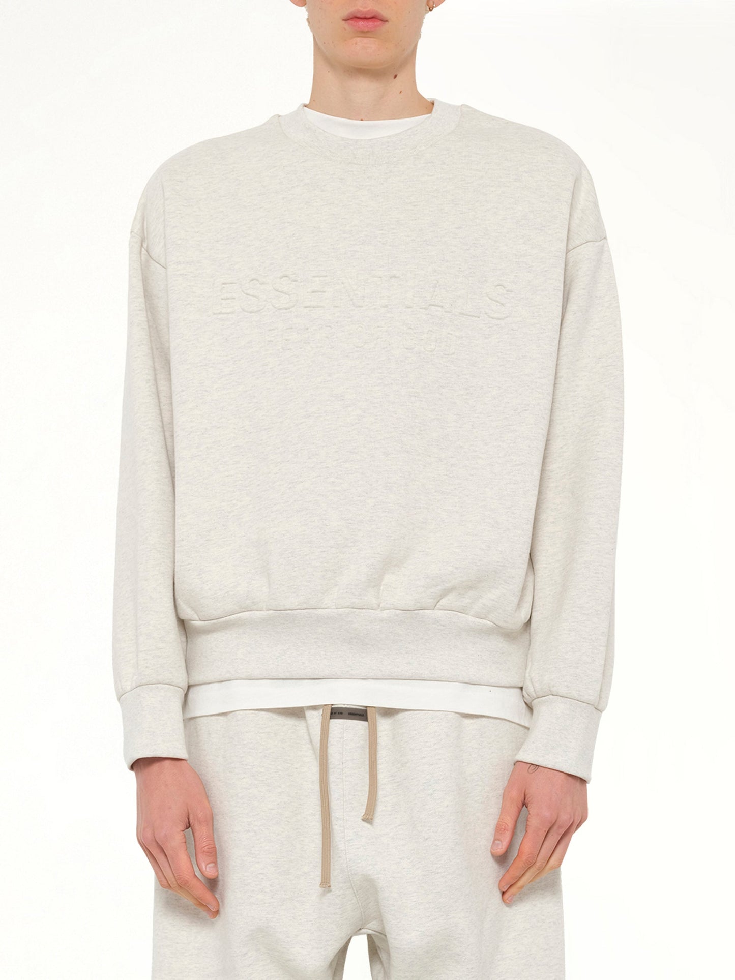 Image of a model wearing Outerwear. Product name - Classic Crewneck Sweatshirt in Beige colour by brand - FEAR OF GOD ESSENTIALS