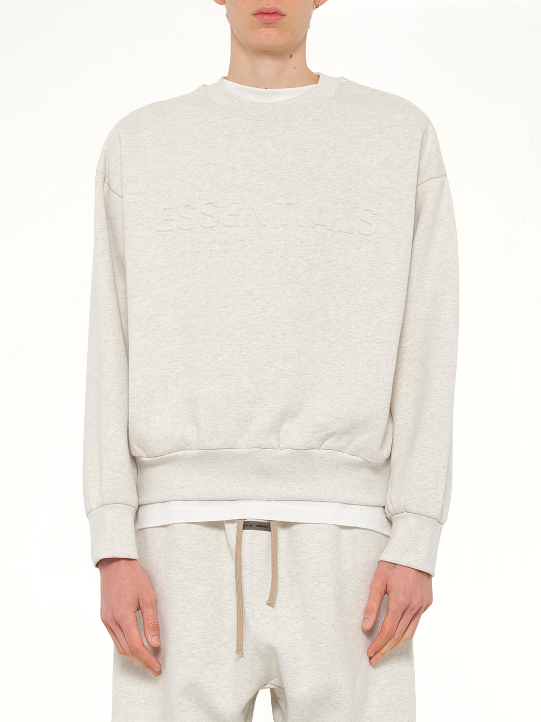 Image of a model wearing Outerwear. Product name - Classic Crewneck Sweatshirt in Beige colour by brand - FEAR OF GOD ESSENTIALS