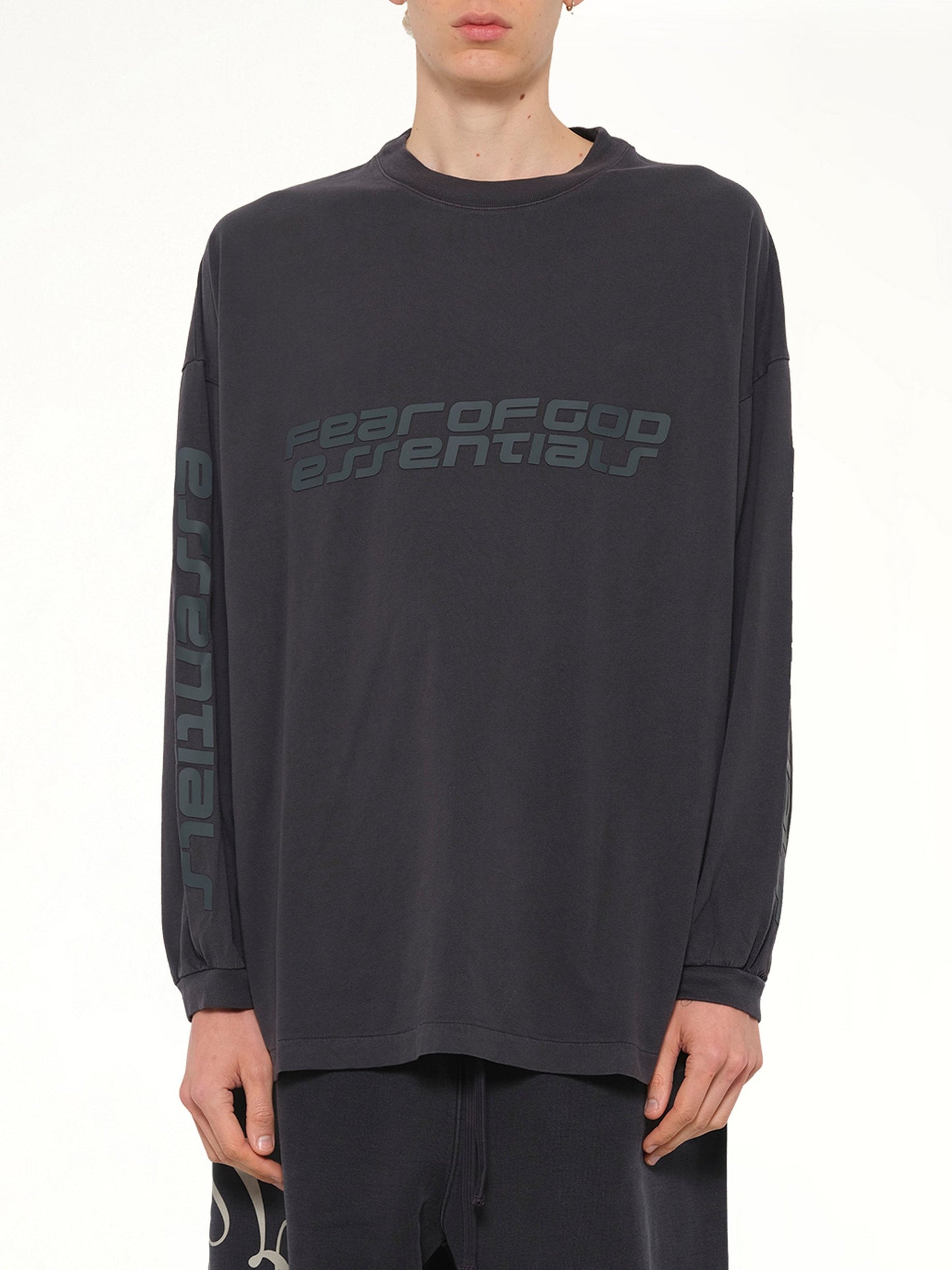 Image of a model wearing Tops. Product name - 90's Long Sleeve T-Shirt in Black colour by brand - FEAR OF GOD ESSENTIALS