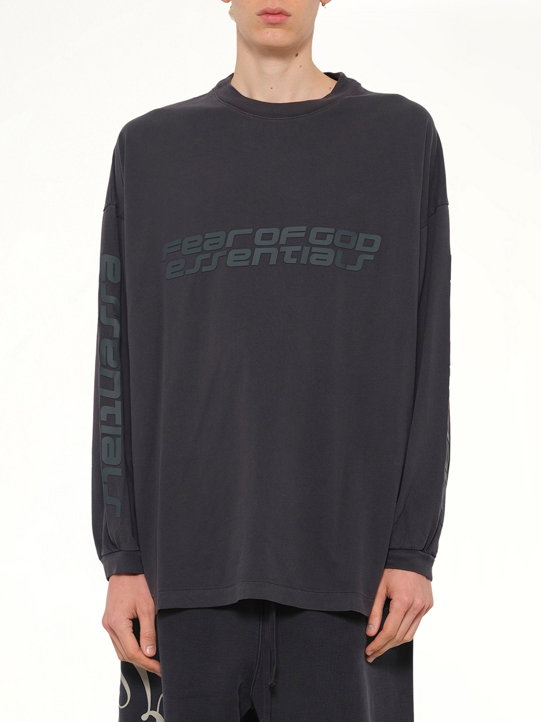 Image of a model wearing Tops. Product name - 90's Long Sleeve T-Shirt in Black colour by brand - FEAR OF GOD ESSENTIALS