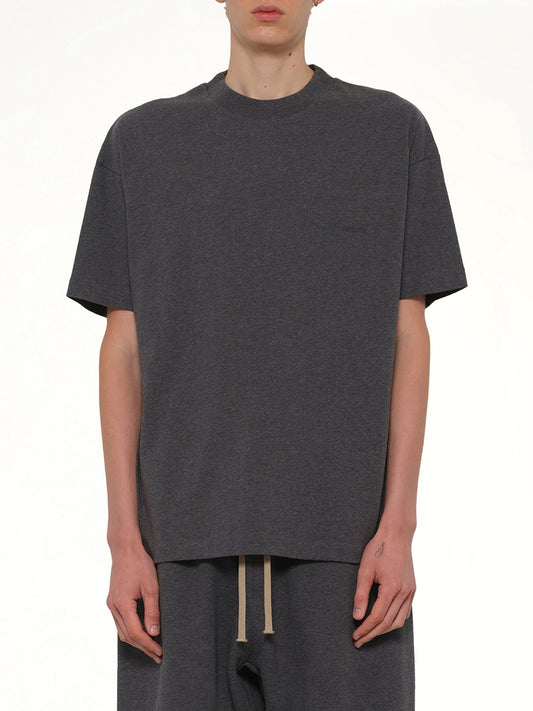 Image of a model wearing Tops. Product name - Classic Short Sleeve T-Shirt in Charcoal Heather colour by brand - FEAR OF GOD ESSENTIALS
