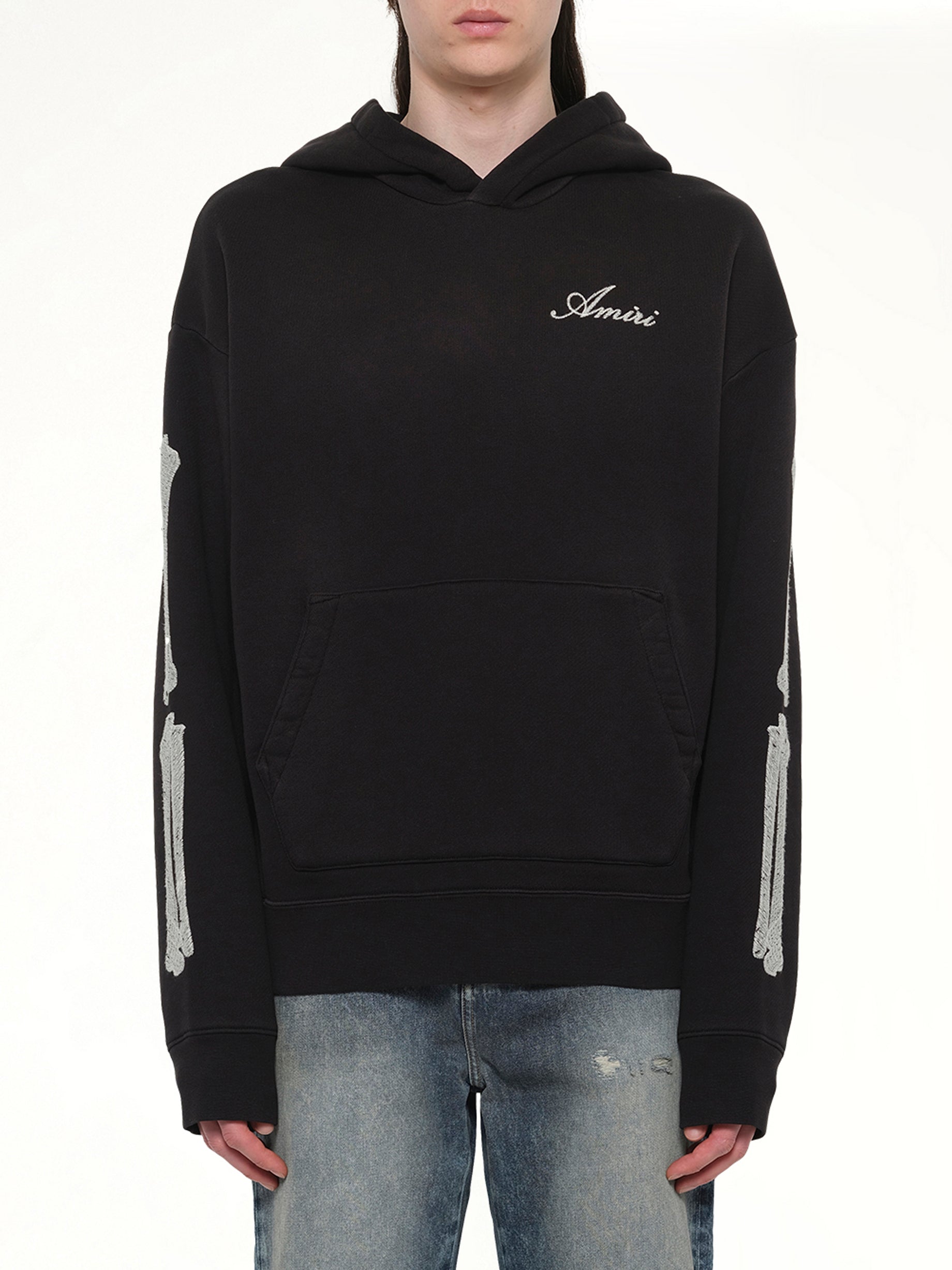 Image of a model wearing Outerwear. Product name - Bones Oversized Hoodie in Black colour by brand - AMIRI