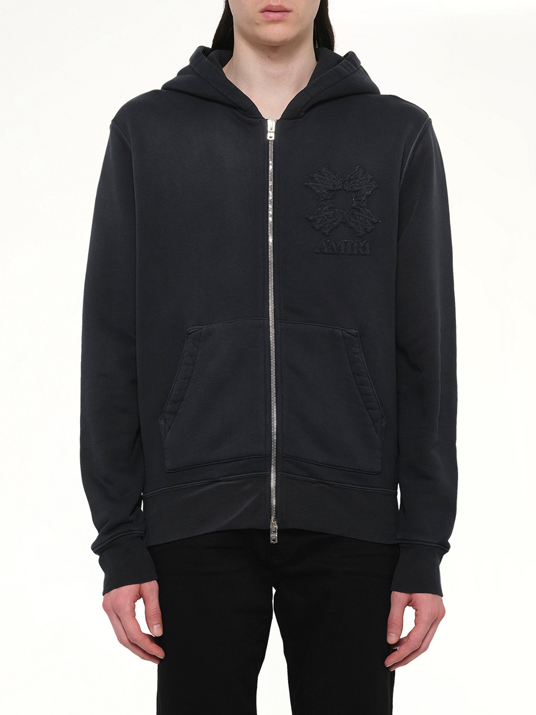 Image of a model wearing Outerwear. Product name - MA Quad Zip Hoodie in Black colour by brand - AMIRI