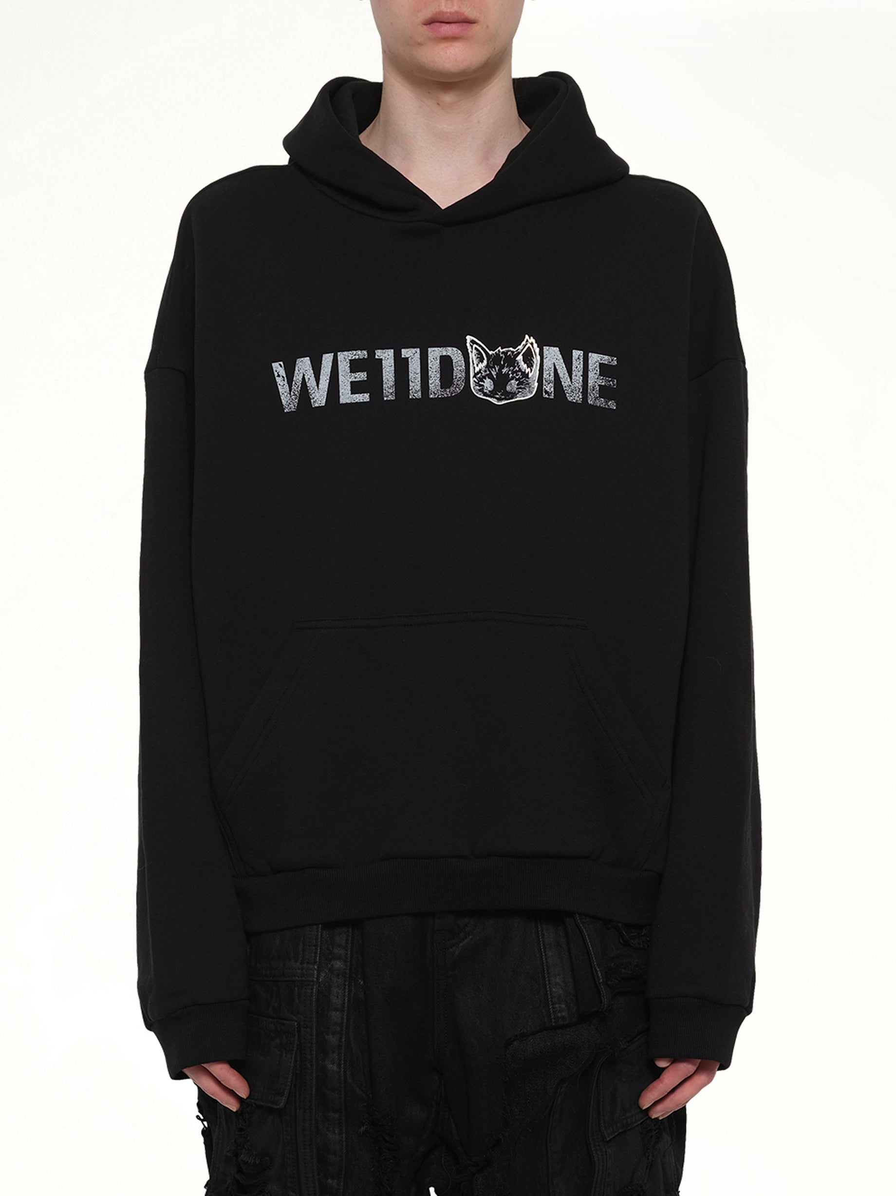 Image of a model wearing Outerwear. Product name - Amber Logo Hoodie in Black colour by brand - WE11DONE