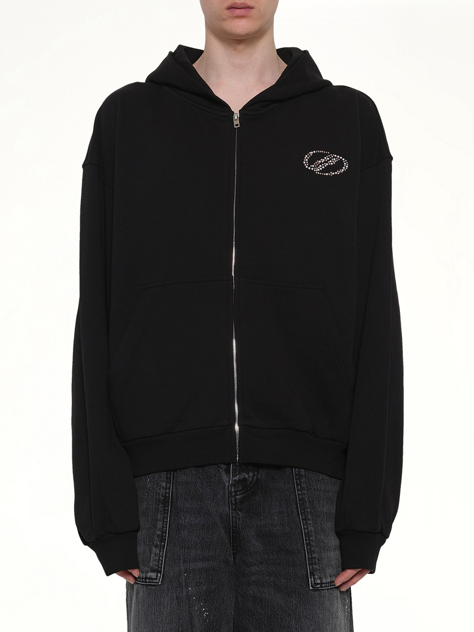 Image of a model wearing Outerwear. Product name - Rhinestone Zip-Up Balloon Hoodie in Black colour by brand - WE11DONE