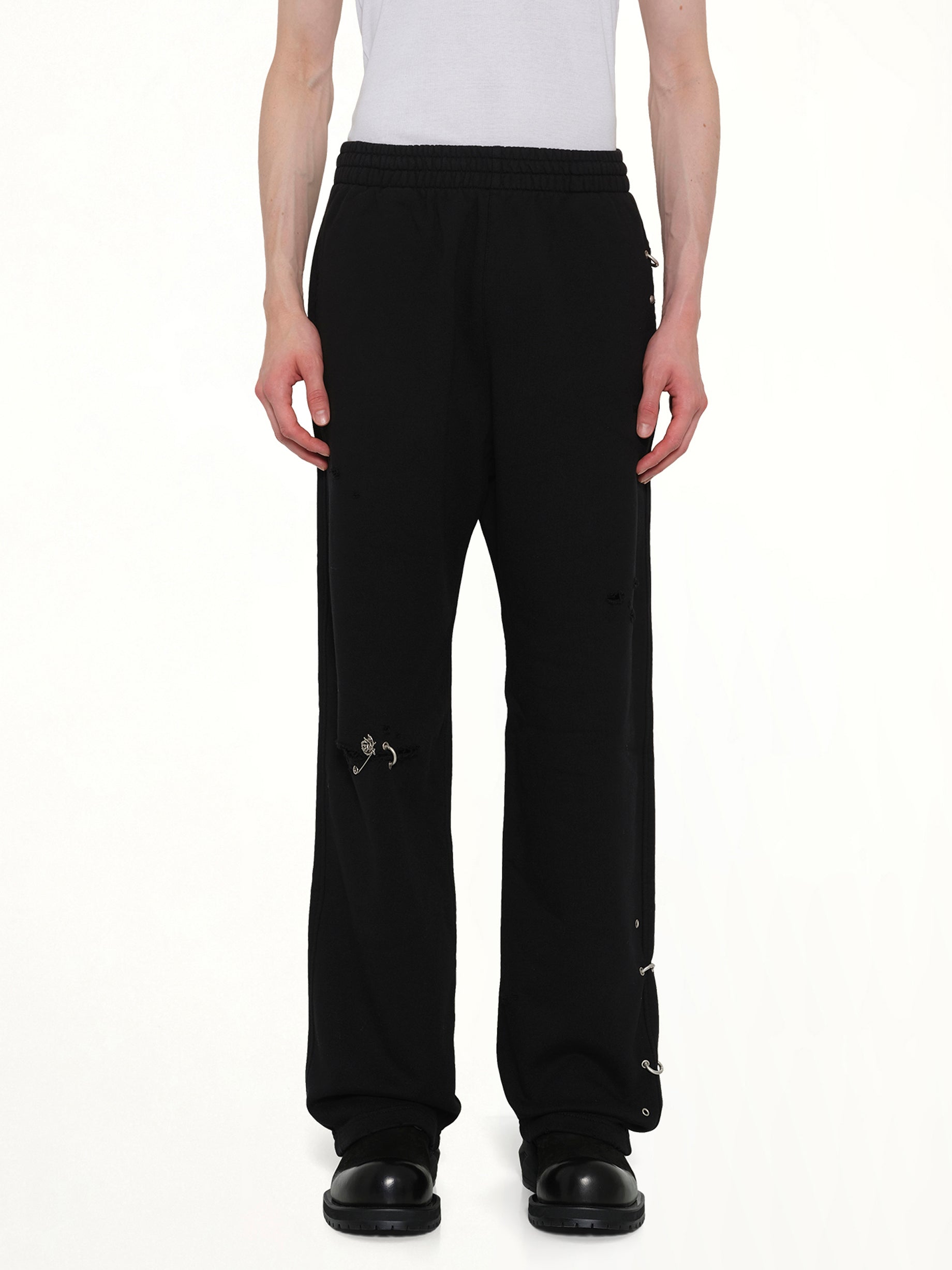 Image of a model wearing Pants. Product name - Piercing Detail Sweatpants in Black colour by brand - WE11DONE