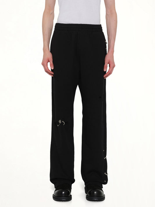 Image of a model wearing Pants. Product name - Piercing Detail Sweatpants in Black colour by brand - WE11DONE