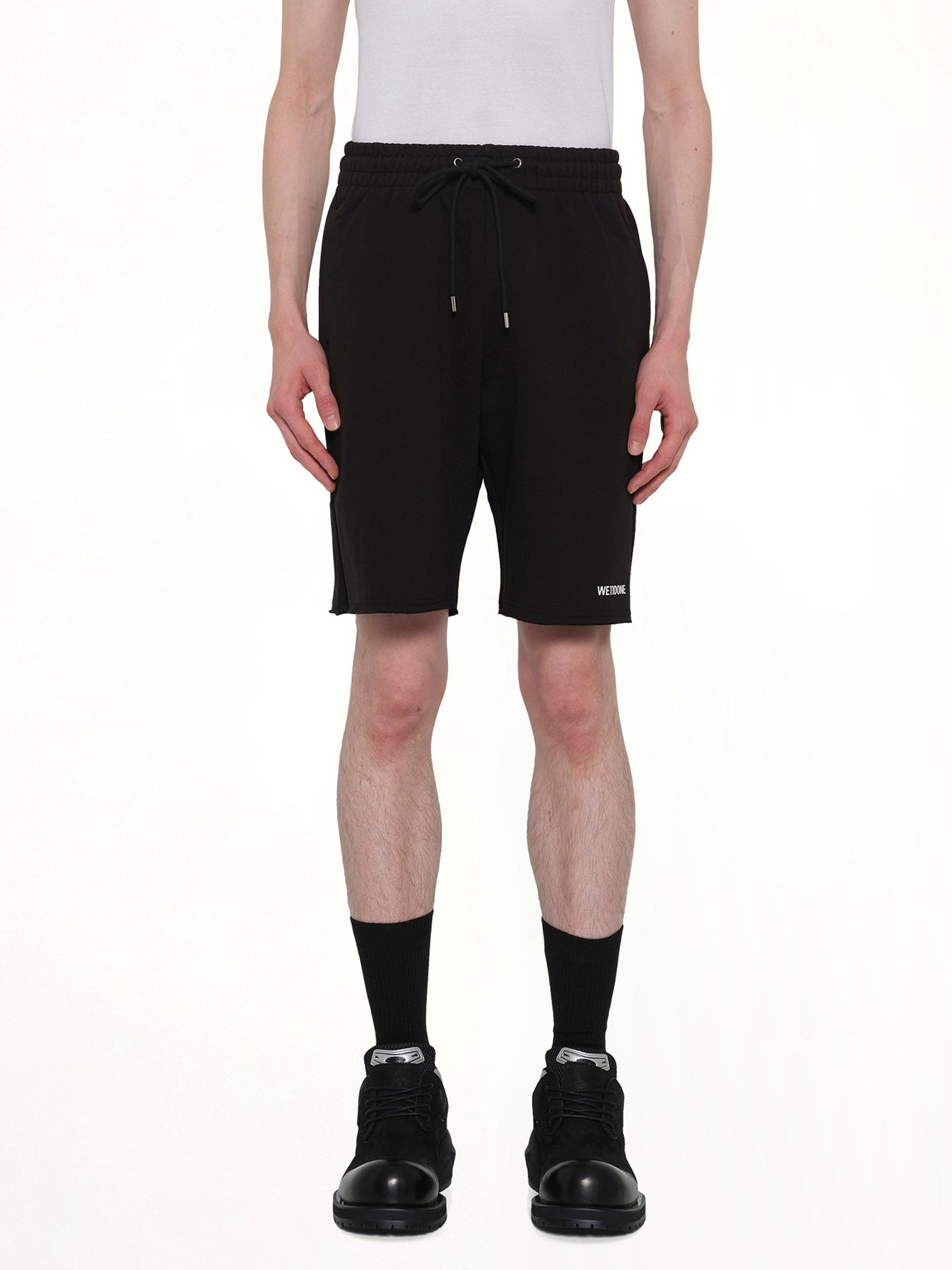 Image of a model wearing Shorts. Product name - Basic Logo Shorts in Black colour by brand - WE11DONE