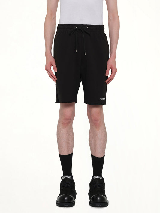 Image of a model wearing Shorts. Product name - Basic Logo Shorts in Black colour by brand - WE11DONE