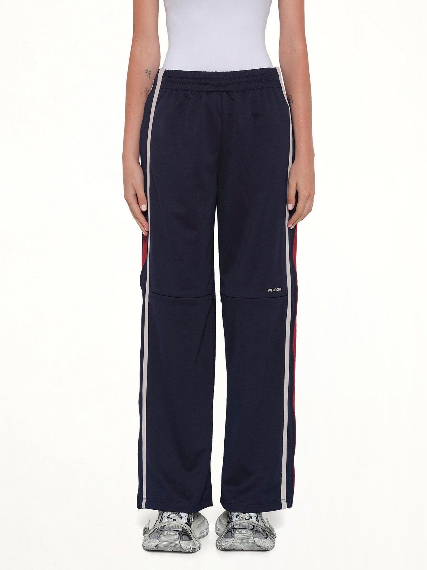 Image of a model wearing Pants. Product name - Track Trousers in Navy colour by brand - WE11DONE