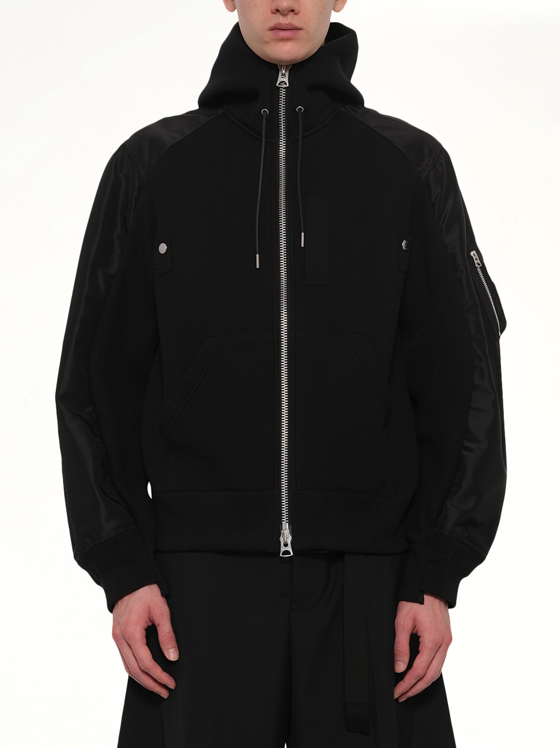 Image of a model wearing Outerwear. Product name - Sponge Sweat Hoodie in Black colour by brand - SACAI