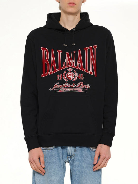 Image of a model wearing Outerwear. Product name - Balmain College Flock Hoodie in Black colour by brand - BALMAIN
