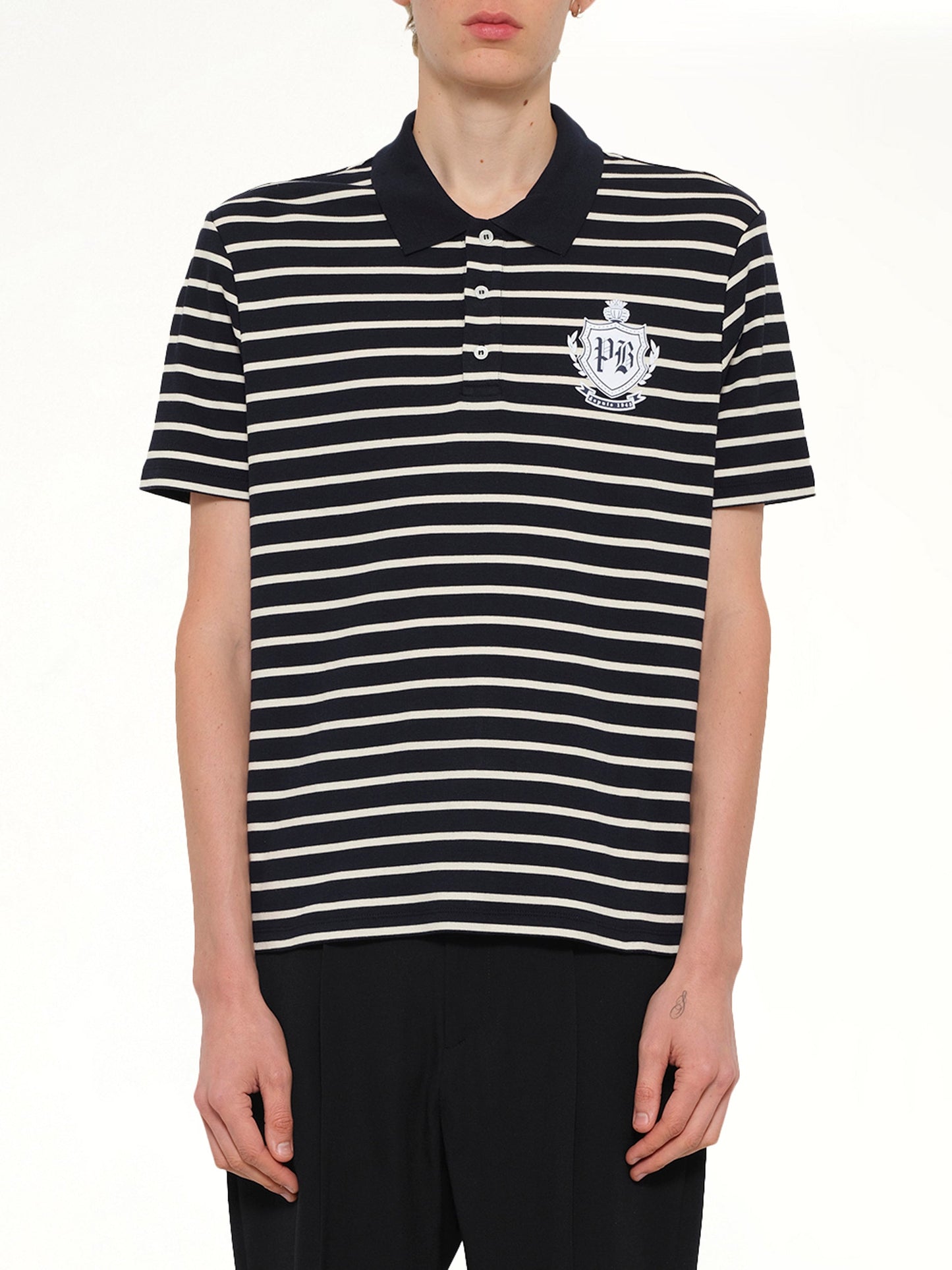 Image of a model wearing Tops. Product name - Marinier College Emblem Polo in Blue colour by brand - BALMAIN