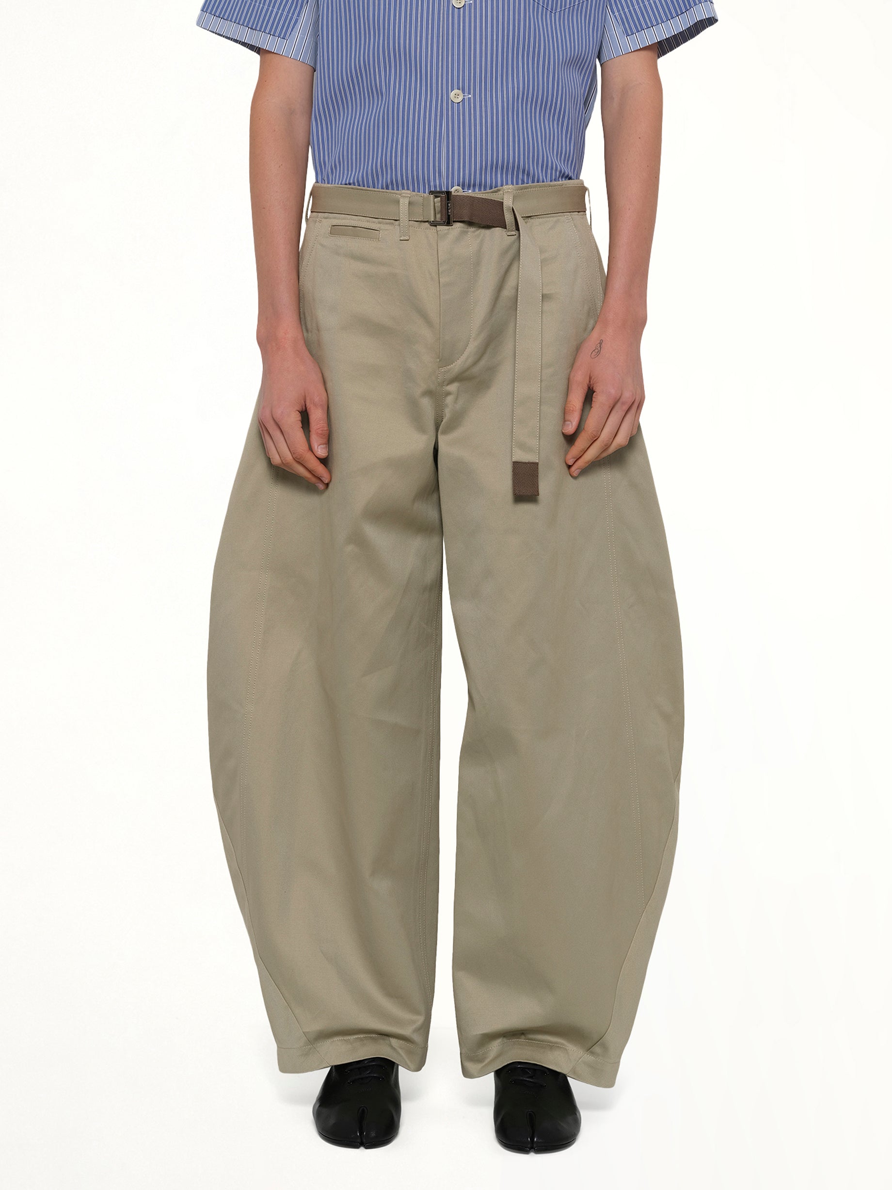 Image of a model wearing Pants. Product name - Cotton Chino Pants in Beige colour by brand - SACAI