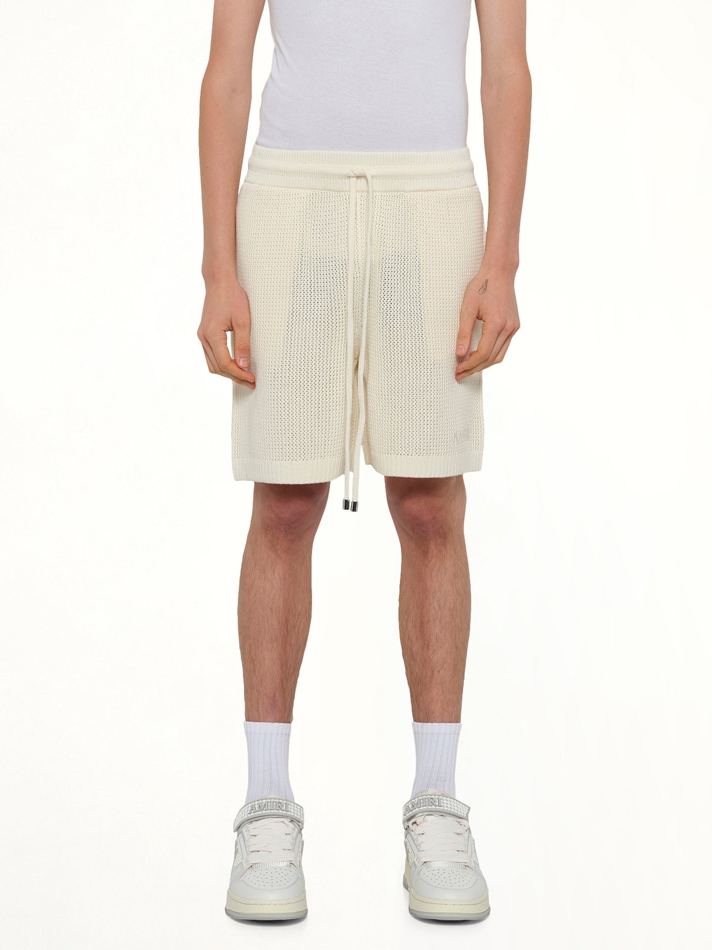 Image of a model wearing Shorts. Product name - Amiri Crochet Mesh Short in Ivory colour by brand - AMIRI