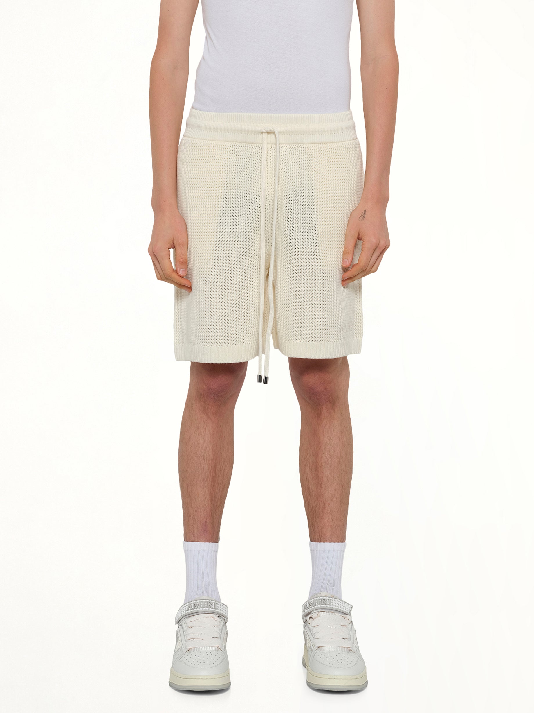 Image of a model wearing Shorts. Product name - Amiri Crochet Mesh Short in Ivory colour by brand - AMIRI