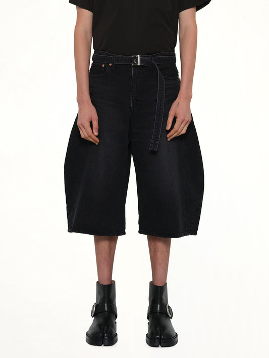 Image of a model wearing Shorts. Product name - Denim Bermuda in Black colour by brand - SACAI