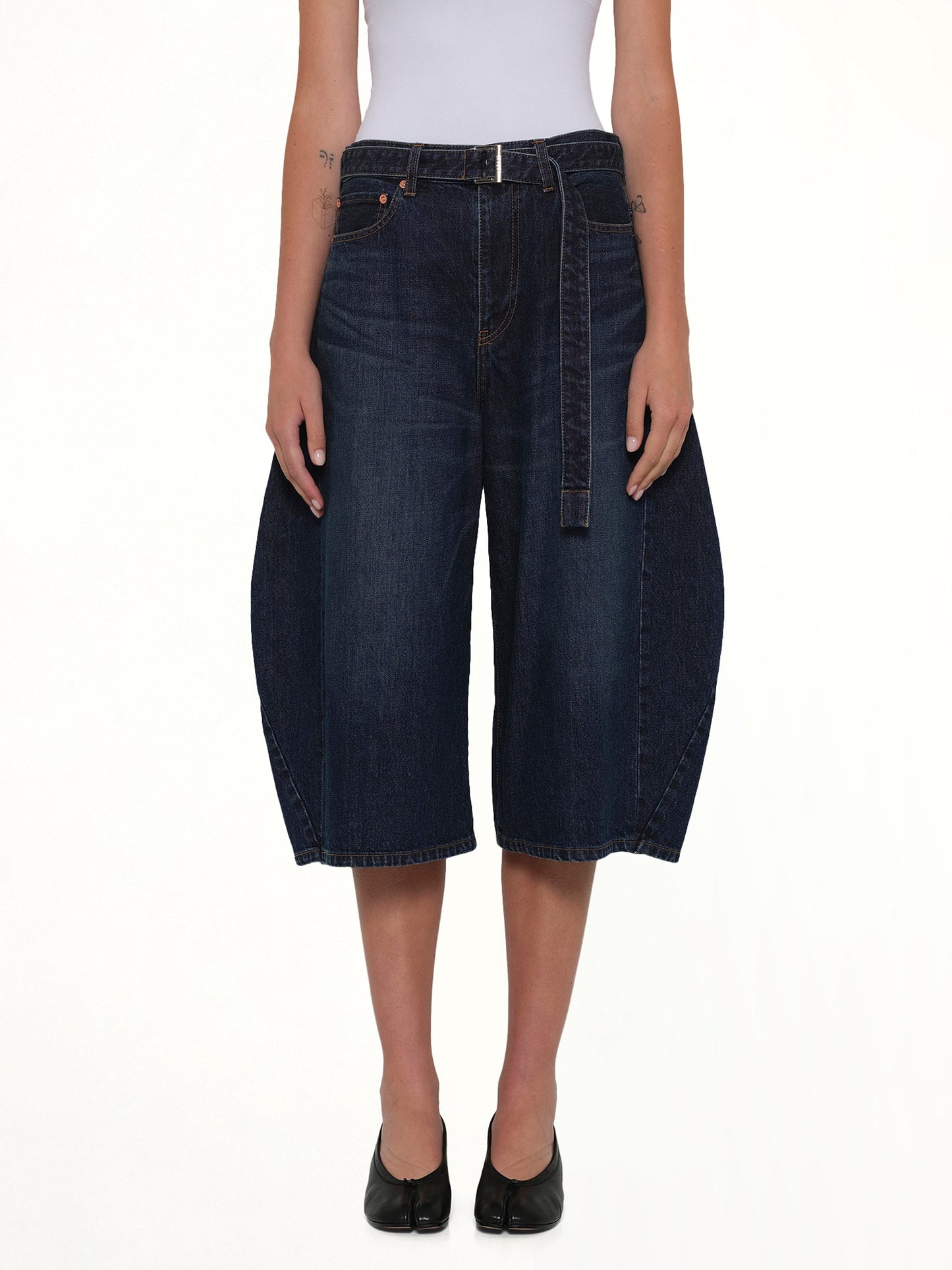 Image of a model wearing Shorts. Product name - Barrel Denim Bermuda Pants in Blue colour by brand - SACAI