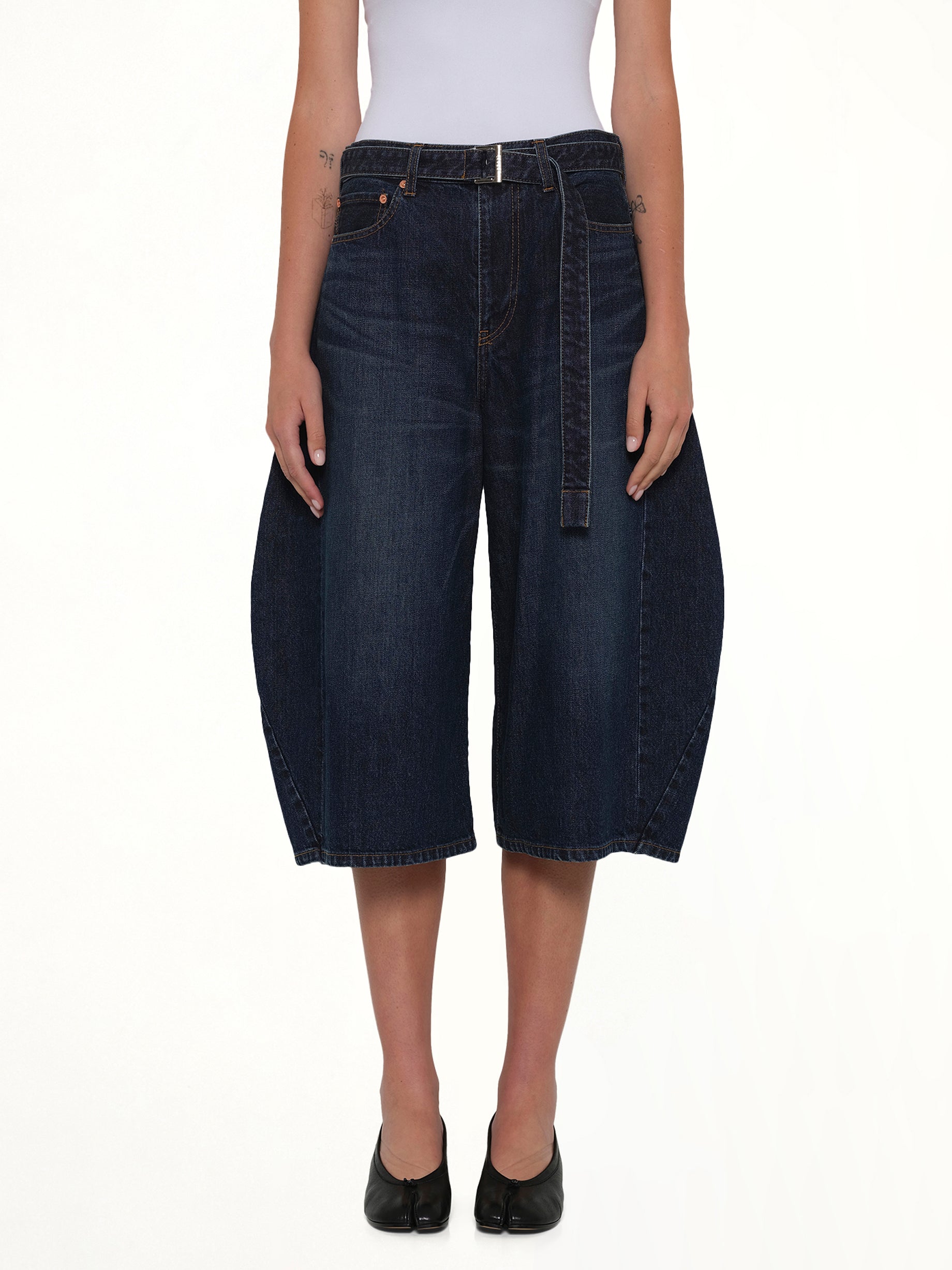 Image of a model wearing Shorts. Product name - Barrel Denim Bermuda Pants in Blue colour by brand - SACAI