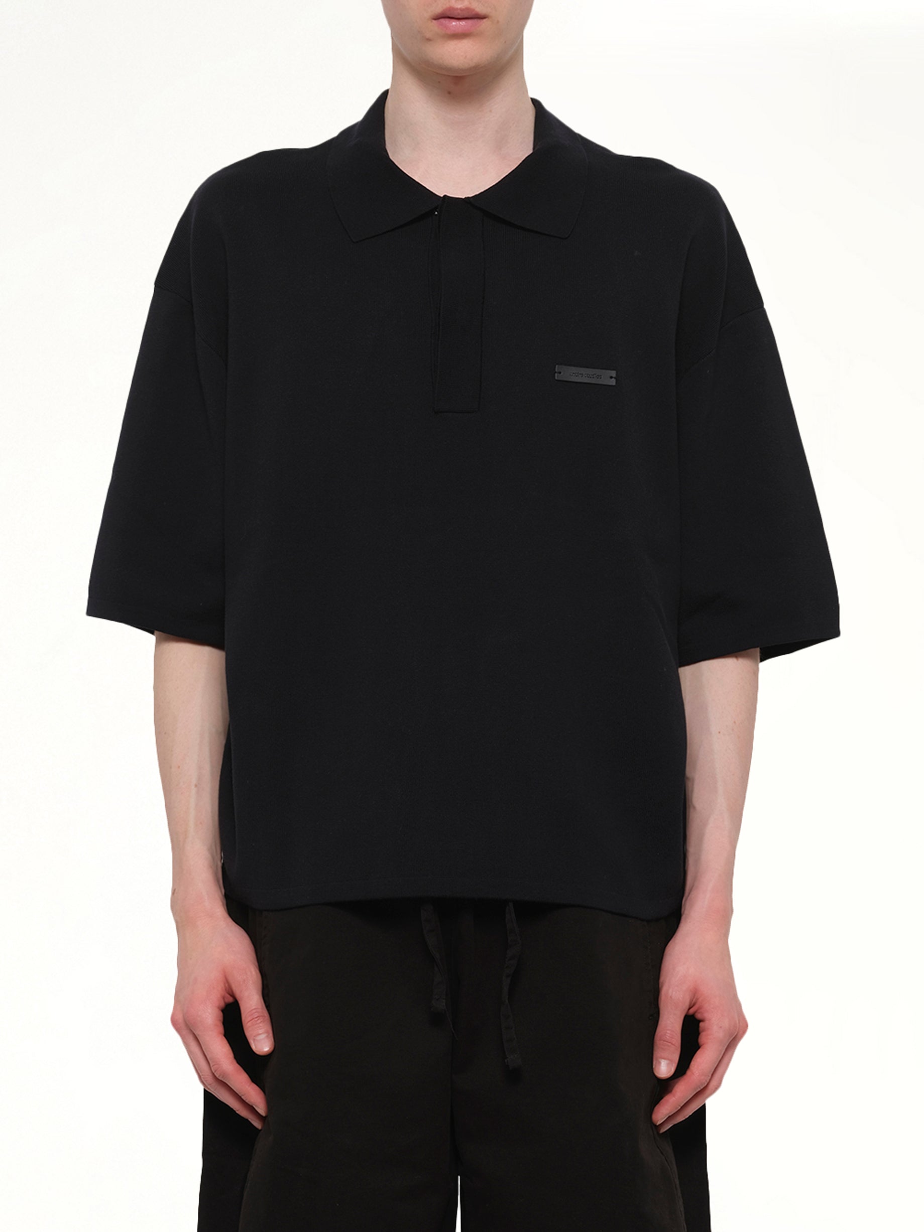 Image of a model wearing Tops. Product name - SS Club Polo in Black colour by brand - ENTIRE STUDIOS