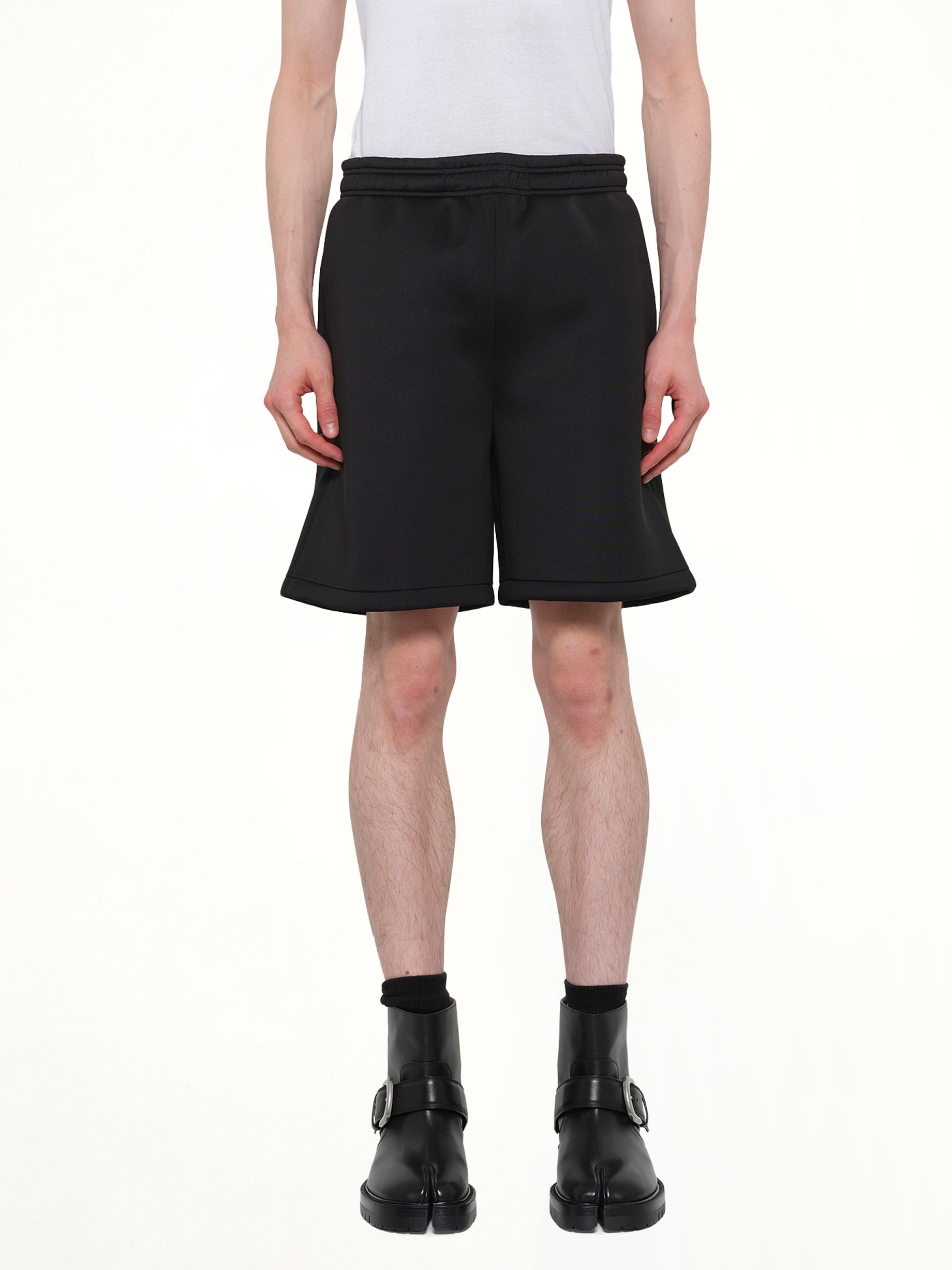 Image of a model wearing Shorts. Product name - Scuba Short in Black colour by brand - ENTIRE STUDIOS