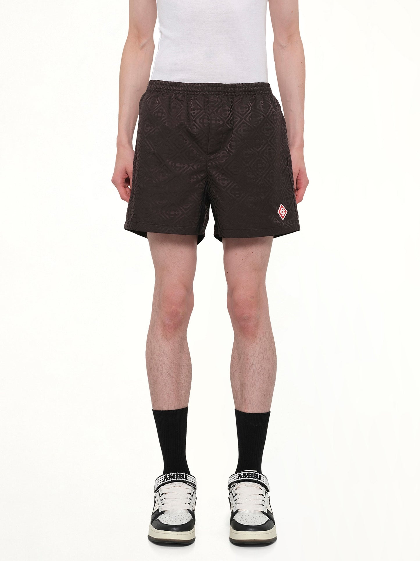 Image of a model wearing Shorts. Product name - Jacquard Swim Shorts in Black colour by brand - CASABLANCA